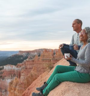 Couple sitting on the cliffs of red rocks 