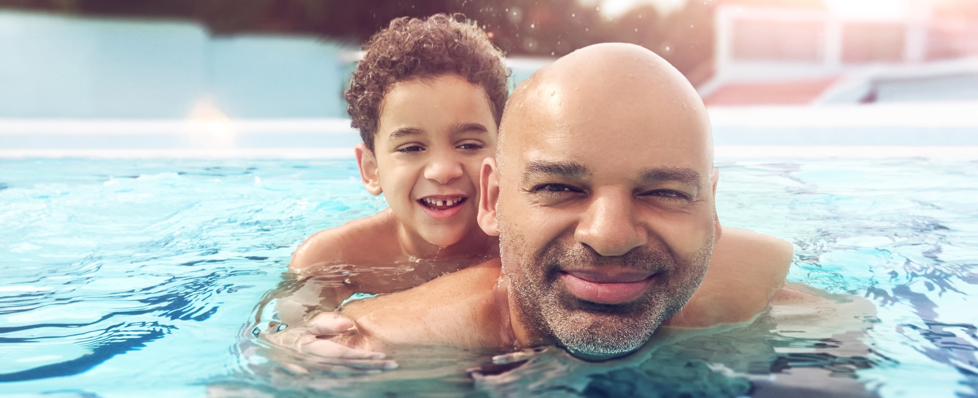 Father and son swimming in a pool