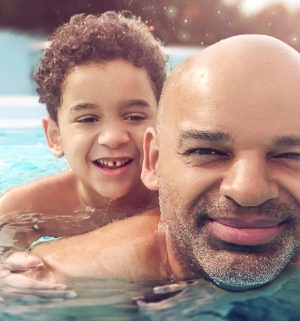 Father and son swimming in a pool