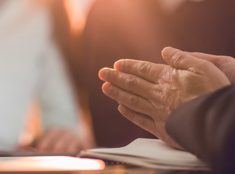 Close up of unrecognizable financial advisor rubbing his hands while made a fraud on his clients