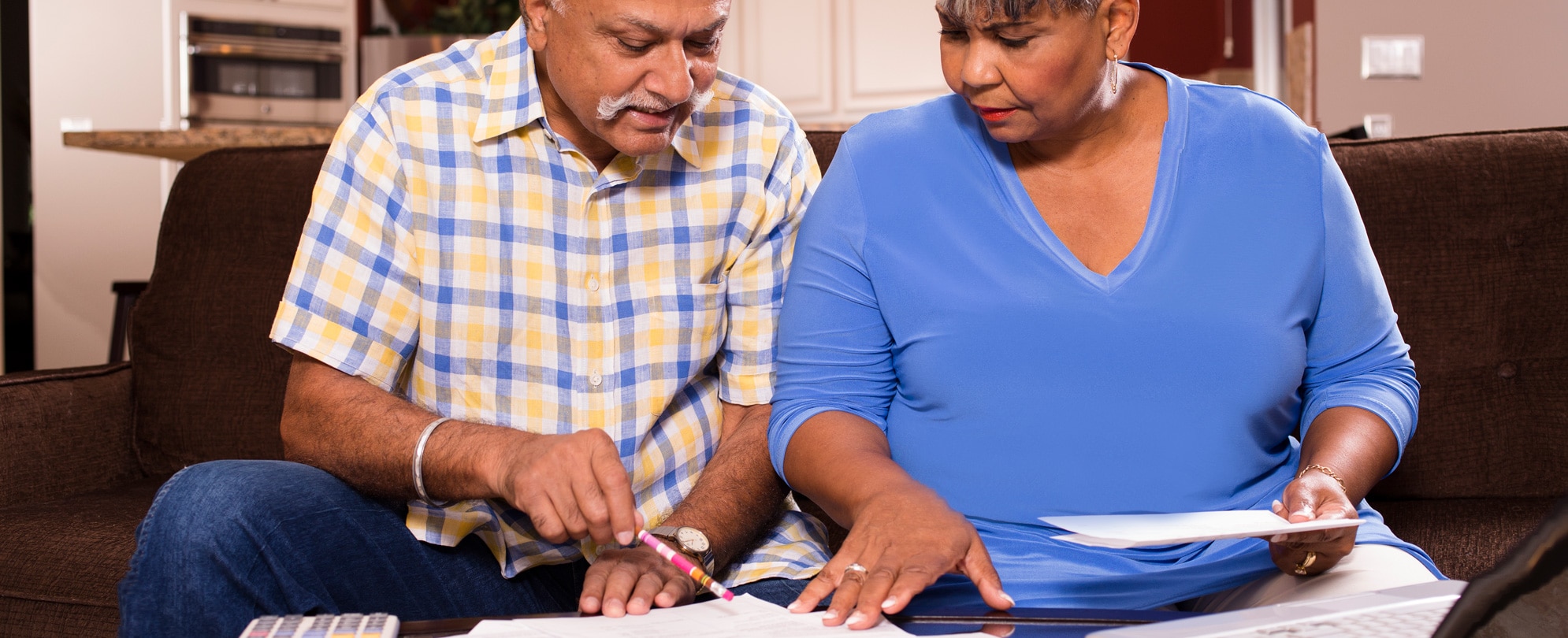 A senior adult couple working together on their monthly bills