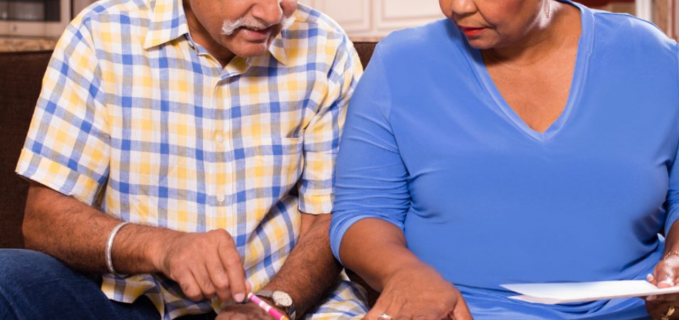 A senior adult couple working together on their monthly bills