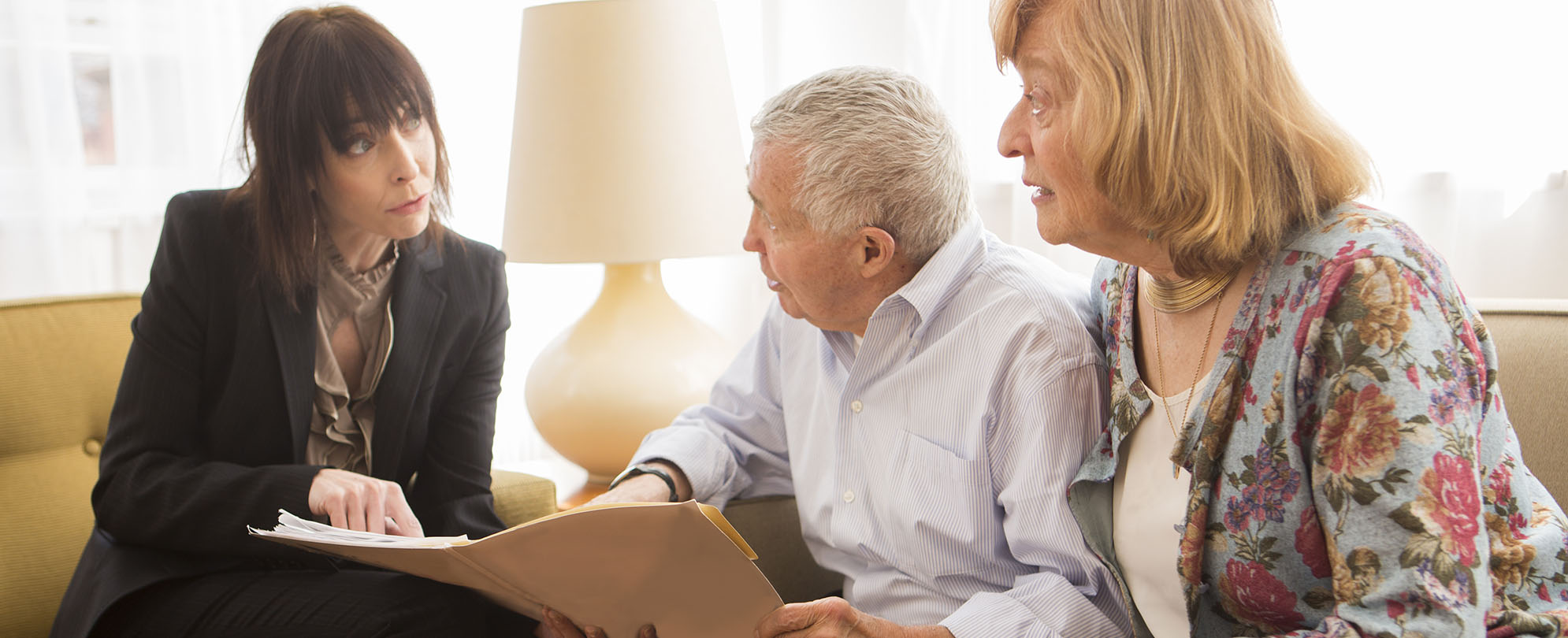 Concerned elderly couple reviewing paperwork with an attorney