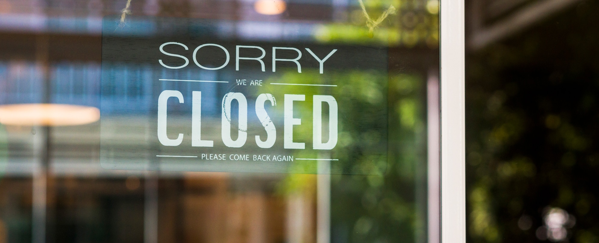 Store closed sign hanging on the window