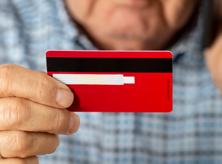 Hands holding a credit card and typing on laptop keyboard 