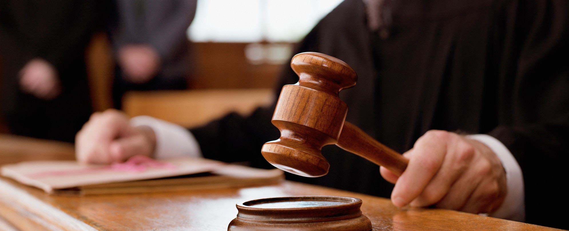 Judge holding gavel in courtroom