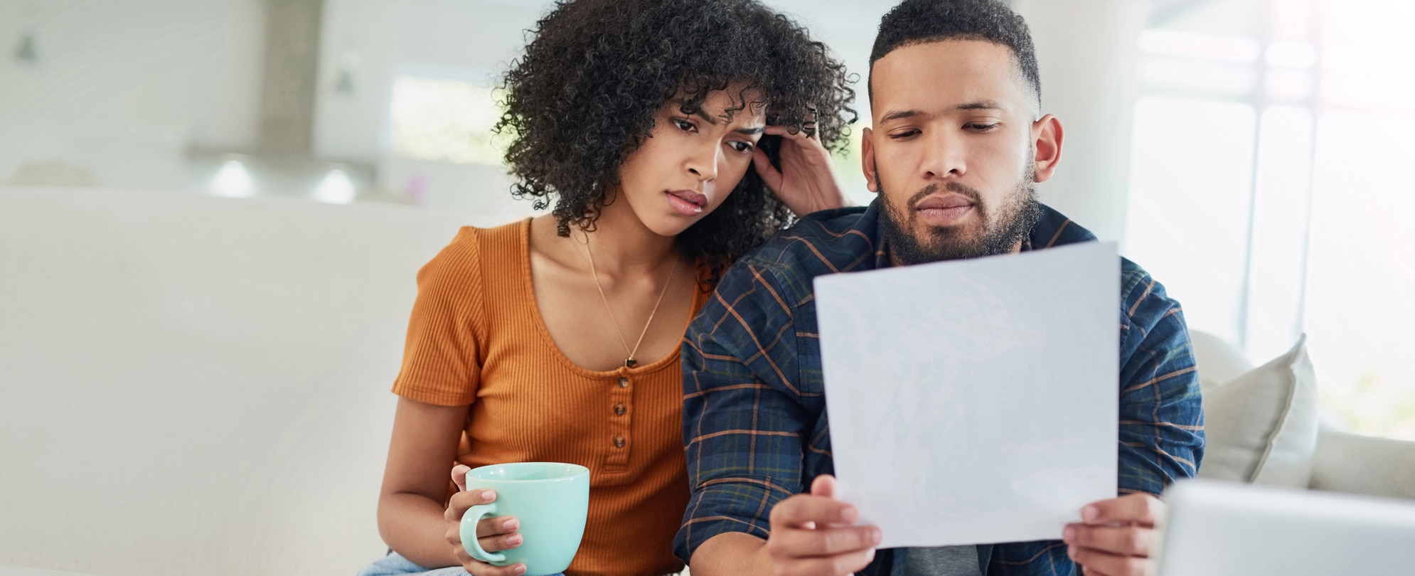 Young couple looking stressed while going over their finances at home