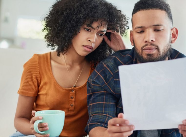 Young couple looking stressed while going over their finances at home