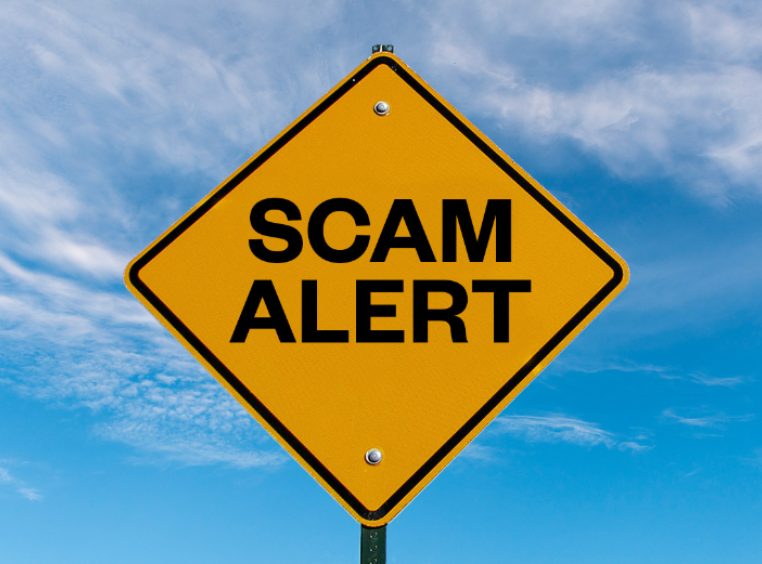 A road sign that reads Scam Alert