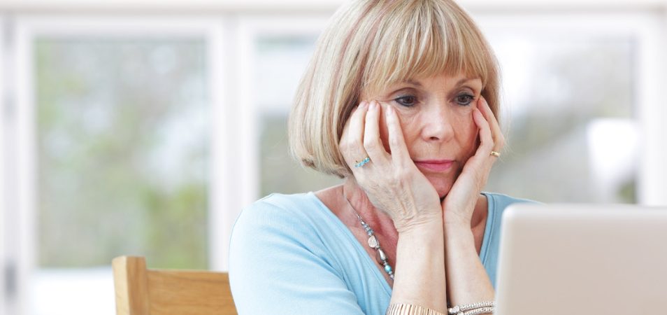 Senior woman looking concerned at laptop