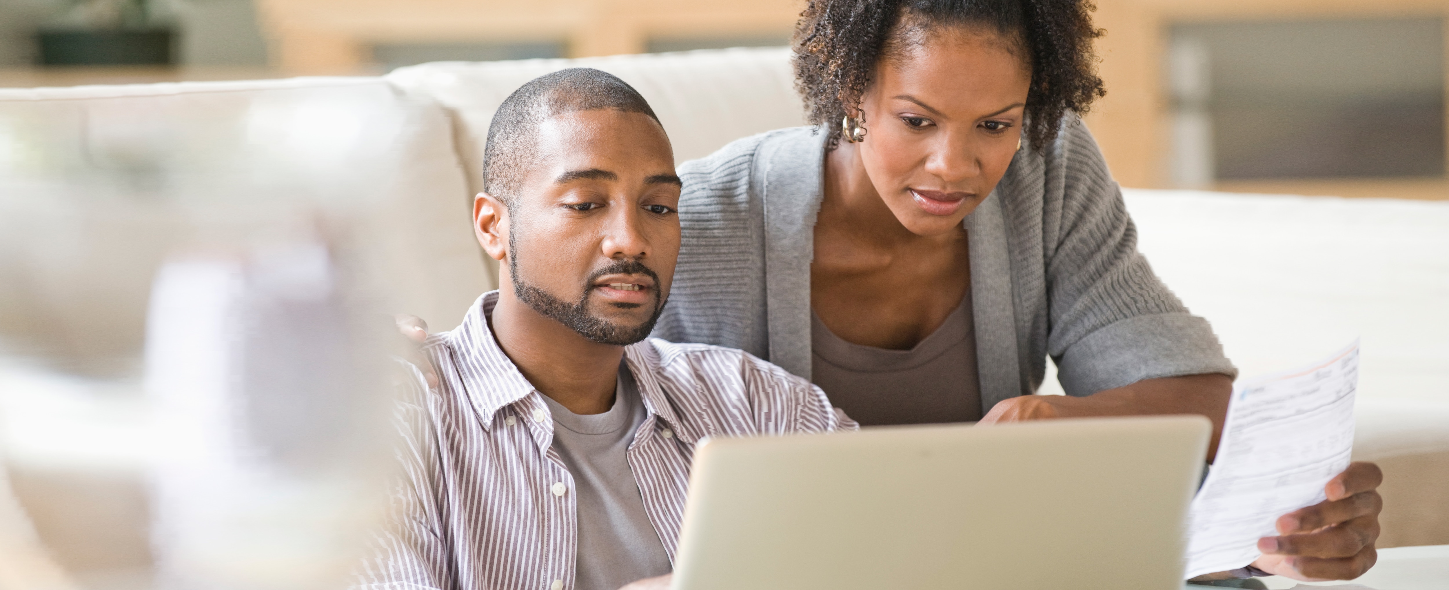 Black couple paying bills using laptop