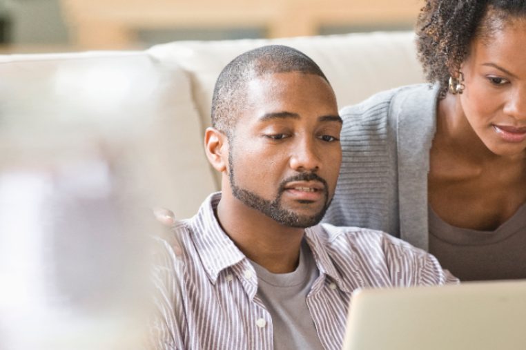 Black couple paying bills using laptop