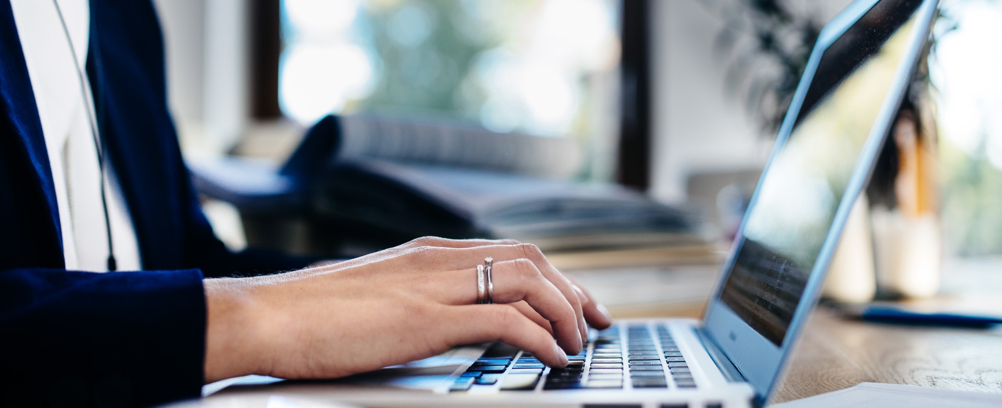 Close up of a woman’s hand typing on a laptop keyboard 