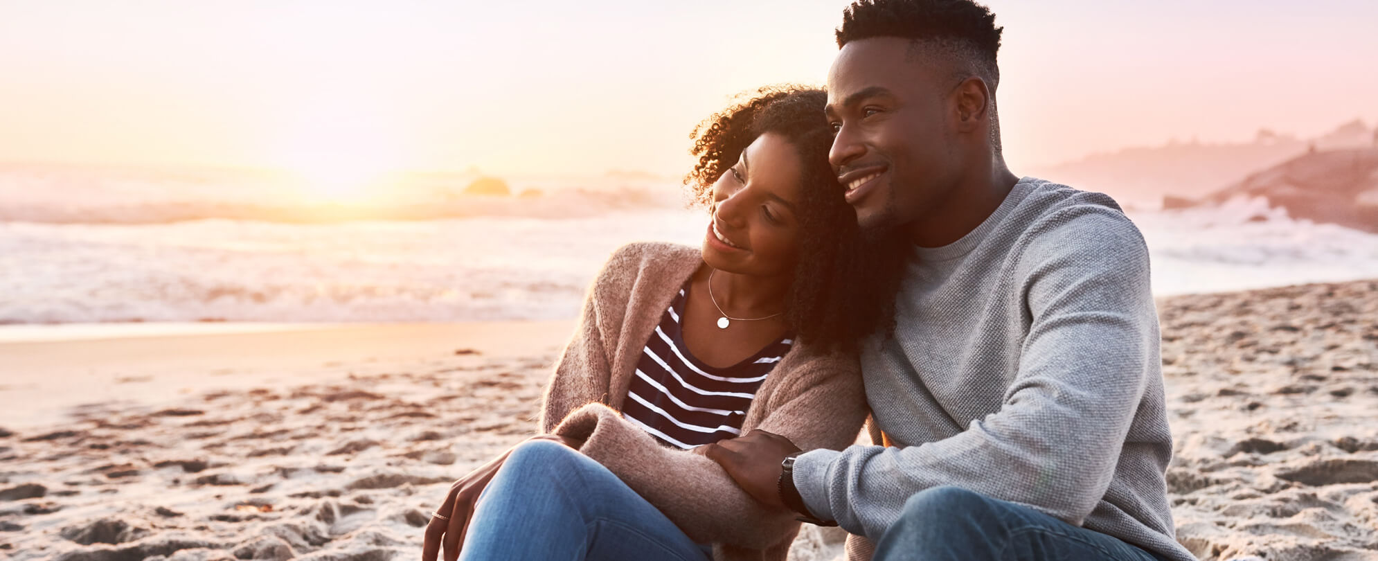 African American couple sitting together on the beach 