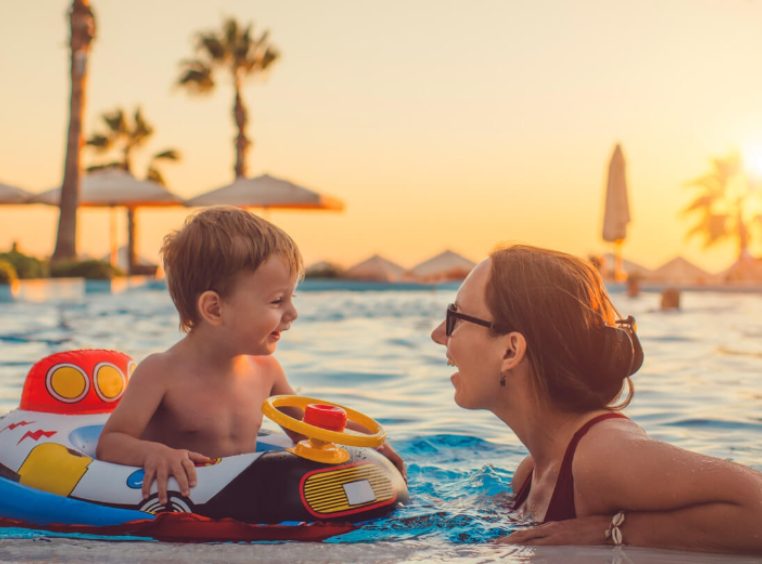 Mother talking to baby son on a pool float 