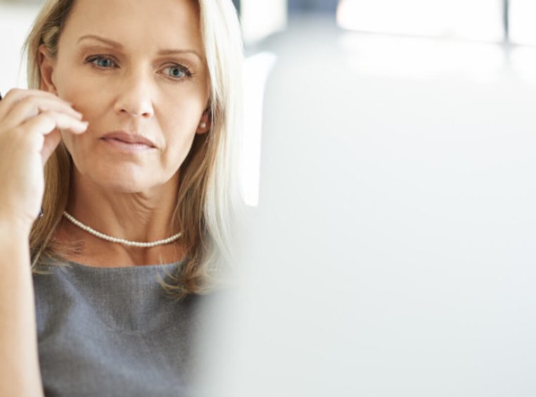 Concerned Mature Businesswoman Looking At Laptop Screen Sitting Touching Face